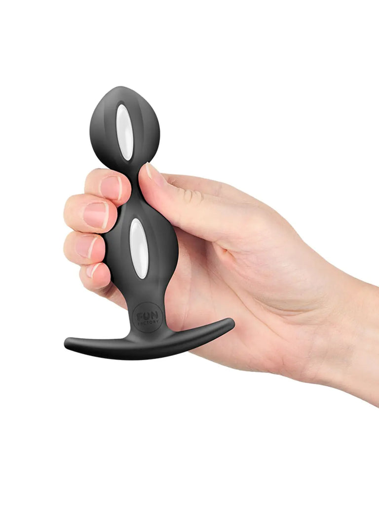 Black FUN FACTORY B Balls Duo held in one hand to show its proportions and secure curved base