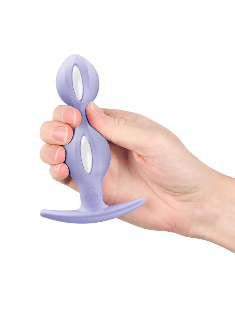 Purple FUN FACTORY B Balls Duo held in one hand to demonstrate its compact size and flexible shape